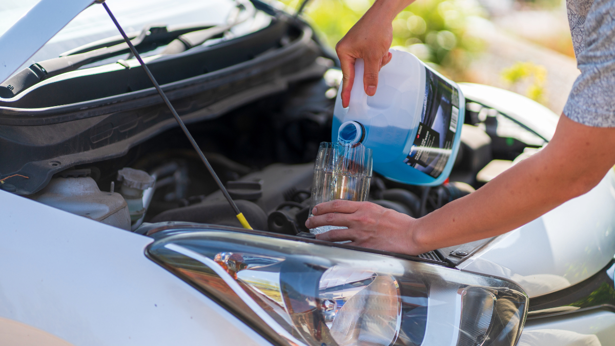 A man pouring antifreeze to use for vehicle maintenance
