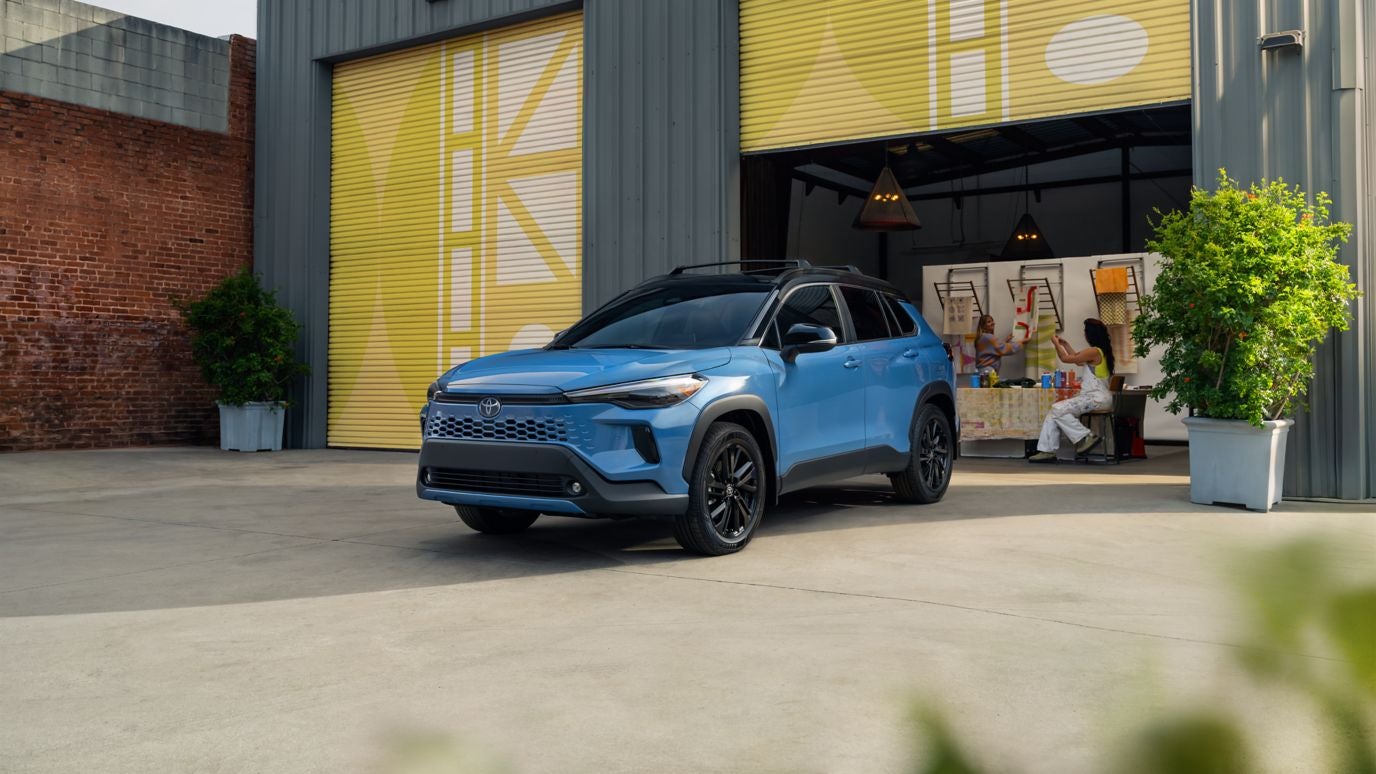 A blue Toyota Corolla Cross coming out of a garage