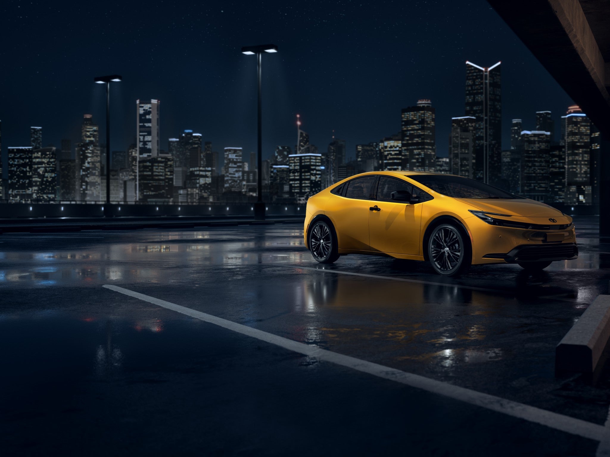 A yellow 2025 Toyota Prius parked in a parking lot at night