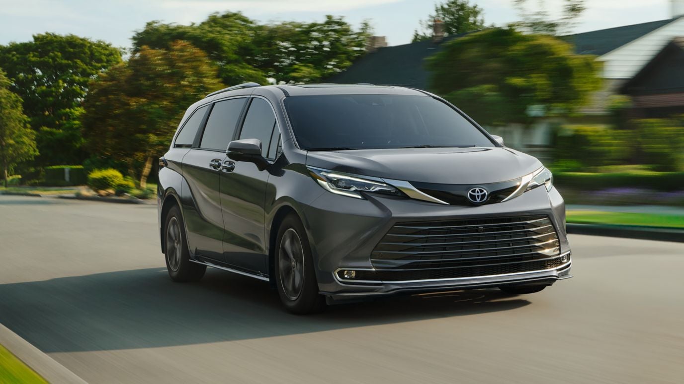 A gray Toyota Sienna driving through the suburbs