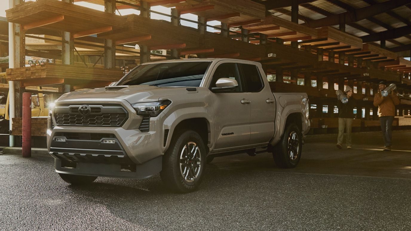 A Toyota Tacoma parked while a pair of people walk up to load its trunk